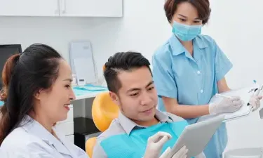 有文凭的牙医助理帮助牙医咨询病人